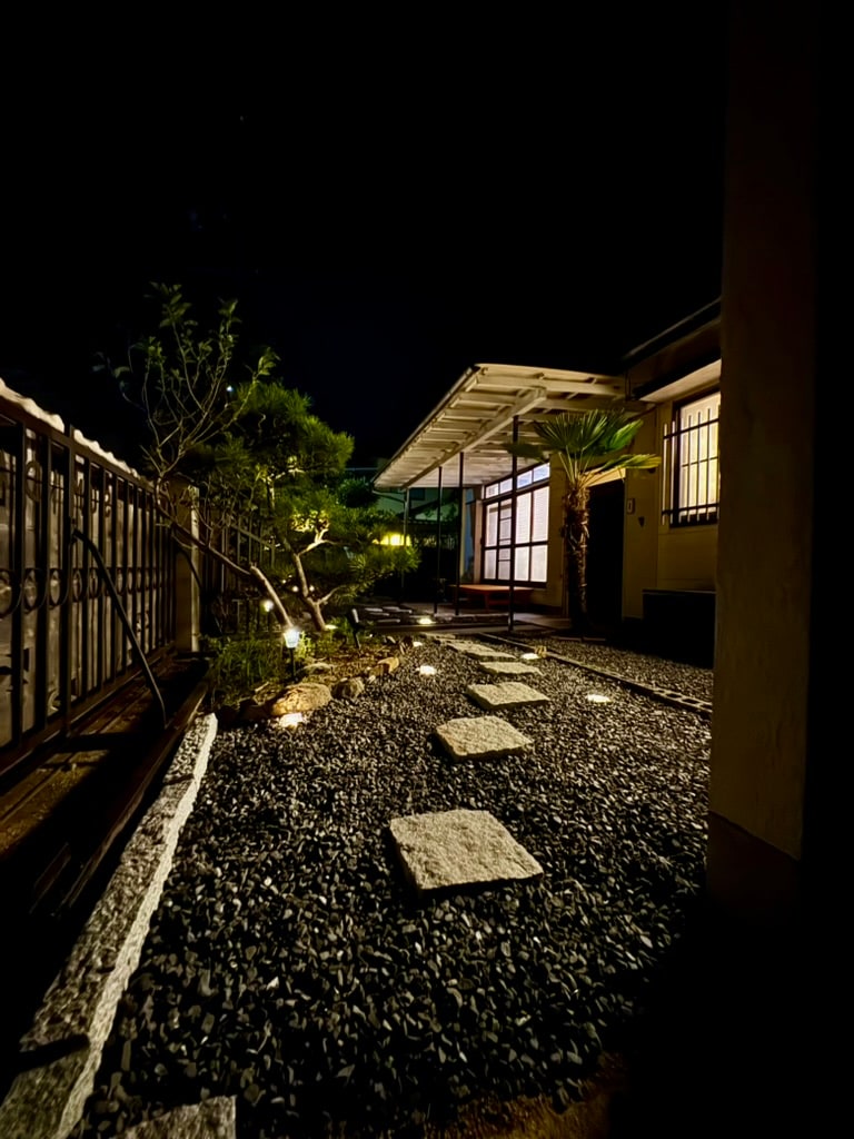 足元の灯りに照らされた夜の庭と飛び石