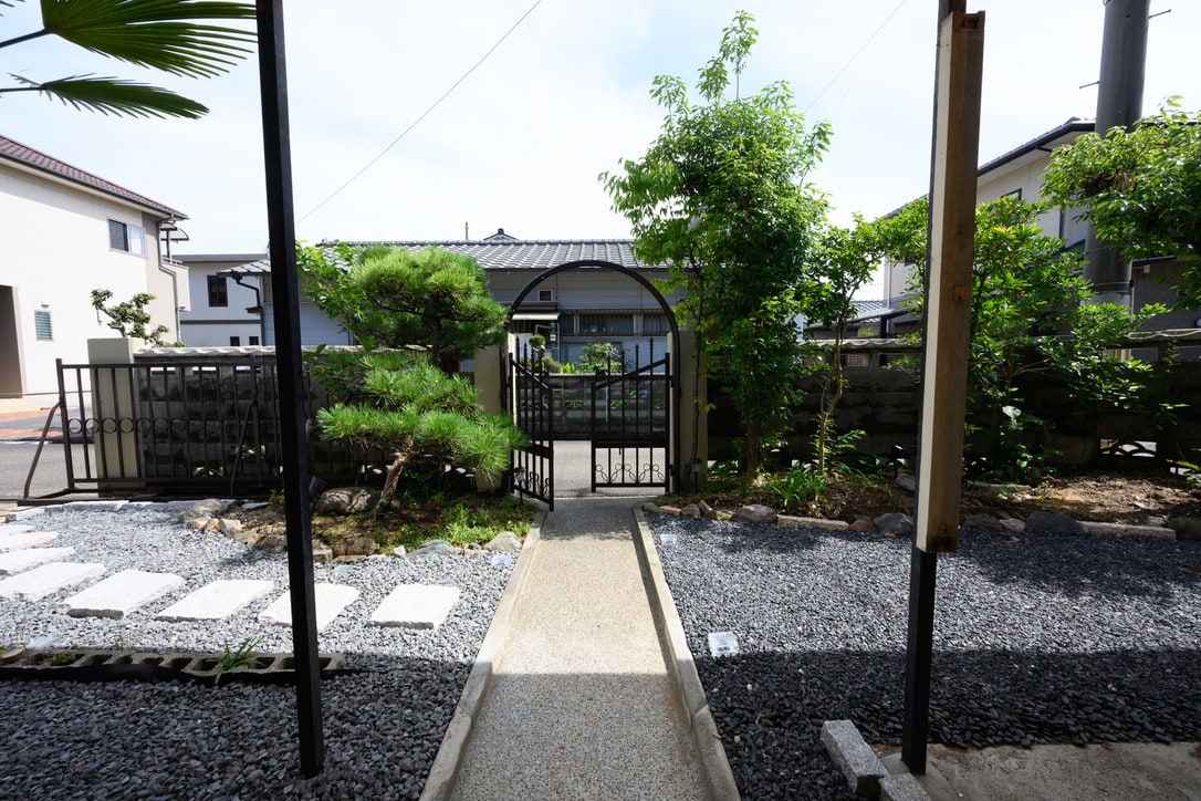家の中から門へ続く昼の庭